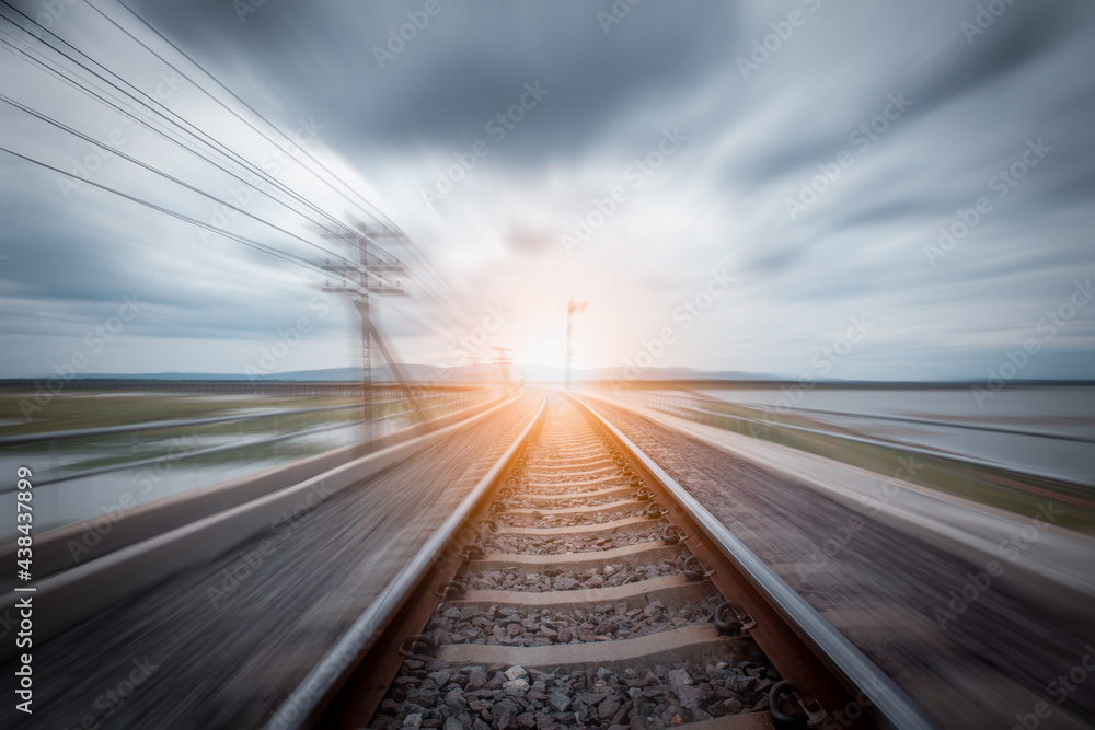 Railroad in motion blur effect at sunset time. Blurred railway. Transportation