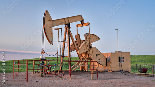oil extraction facility with a pumpjack in a green prairie, Pawnee National Grassland in Colorado in late spring