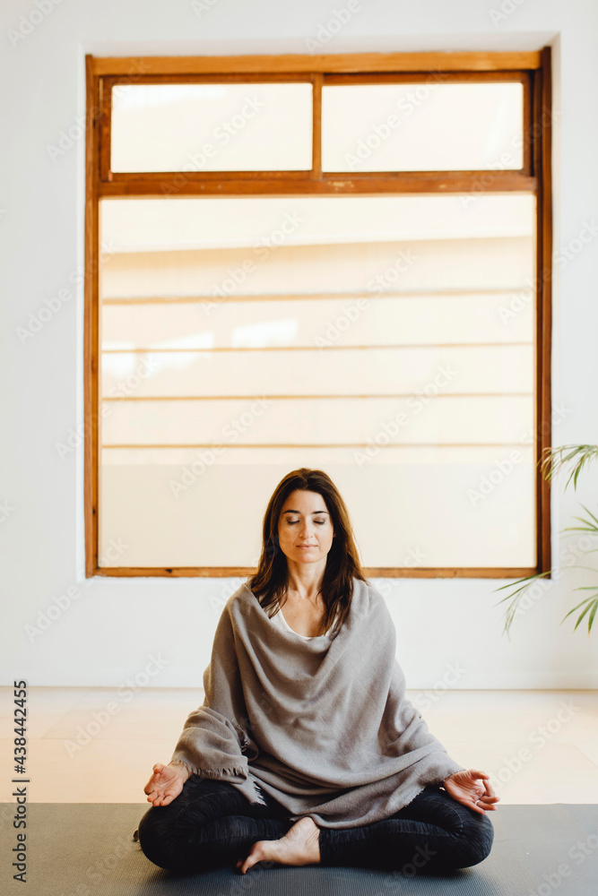 student covered by blanket sitting relaxing after yoga session student covered by blanket sitting relaxing after yoga session