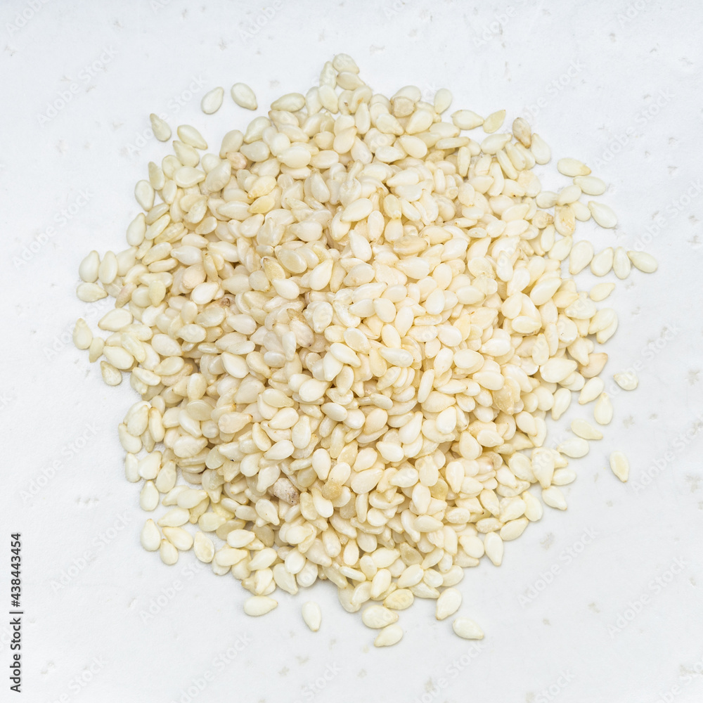 pile of white sesame seeds close up on gray pile of white sesame seeds close up on gray