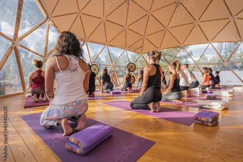 People doing yoga on yoga mats in domed hall photo