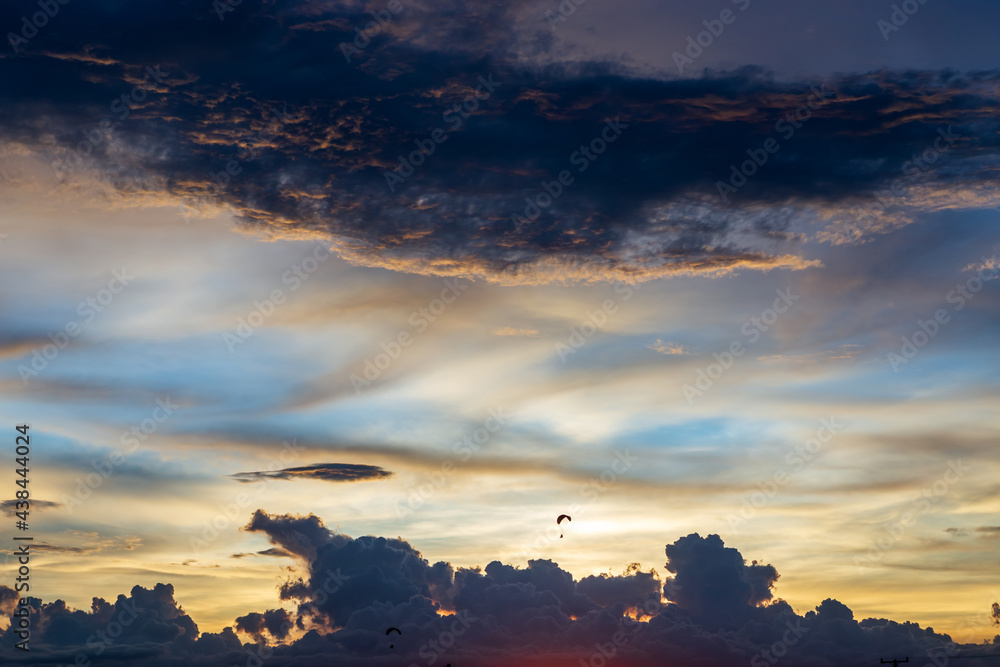 Fototapeta premium Twilight blue bright and orange yellow dramatic sunset sky in countryside or beach colorful cloudscape texture with white clouds air background.