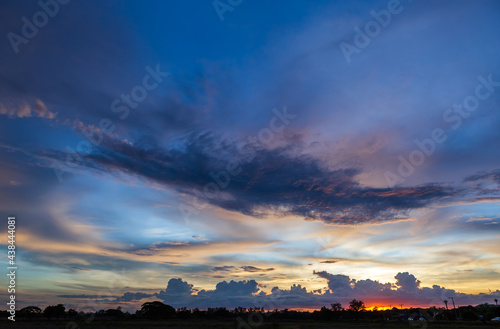 Twilight blue bright and orange yellow dramatic sunset sky in countryside or beach colorful cloudscape texture with white clouds air background.