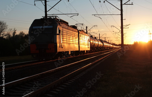 Train with tanks with oil products on the background of sunset