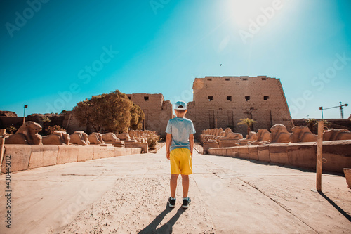 Little boy tourist stands at the entrance to Karnak Temple, Luxor, Egypt.