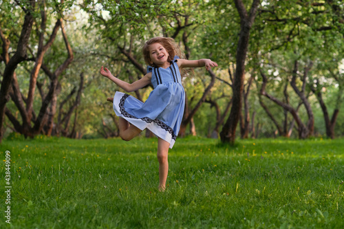 little girl runs barefoot on the grass. happy child on a hot summer day.