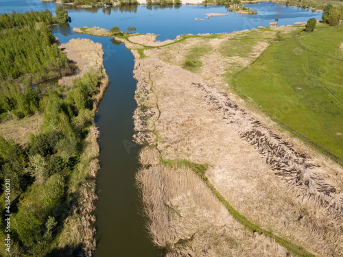River spill on a green meadow. Aerial drone view.