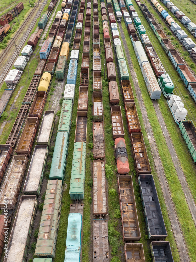 Freight trains on railway tracks. Aerial drone top view. Sunny spring day.