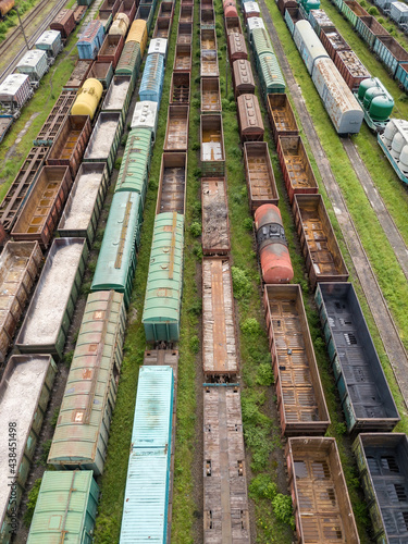 Freight trains on railway tracks. Aerial drone top view. Sunny spring day. © Sergey