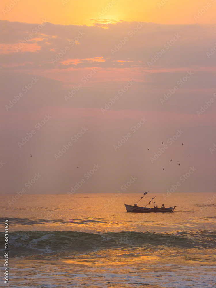 Fototapeta premium Boat fishing in the sea with sunrise light