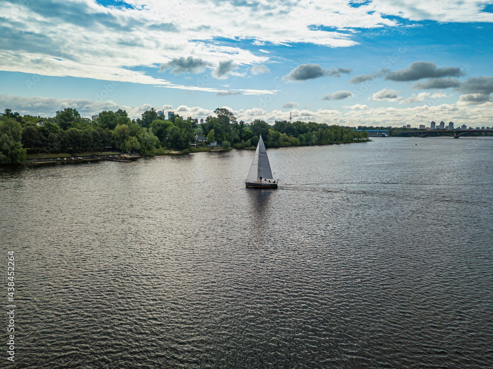 Obraz premium Sailing yacht floats on the river. Aerial drone view.