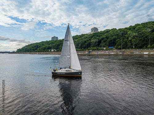 Sailing yacht floats on the river. Aerial drone view.