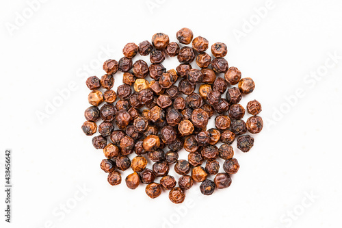 pile of red kampot pepper close up on gray photo