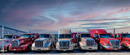 Semi trucks lined up on a parking lot at logistics warehouse