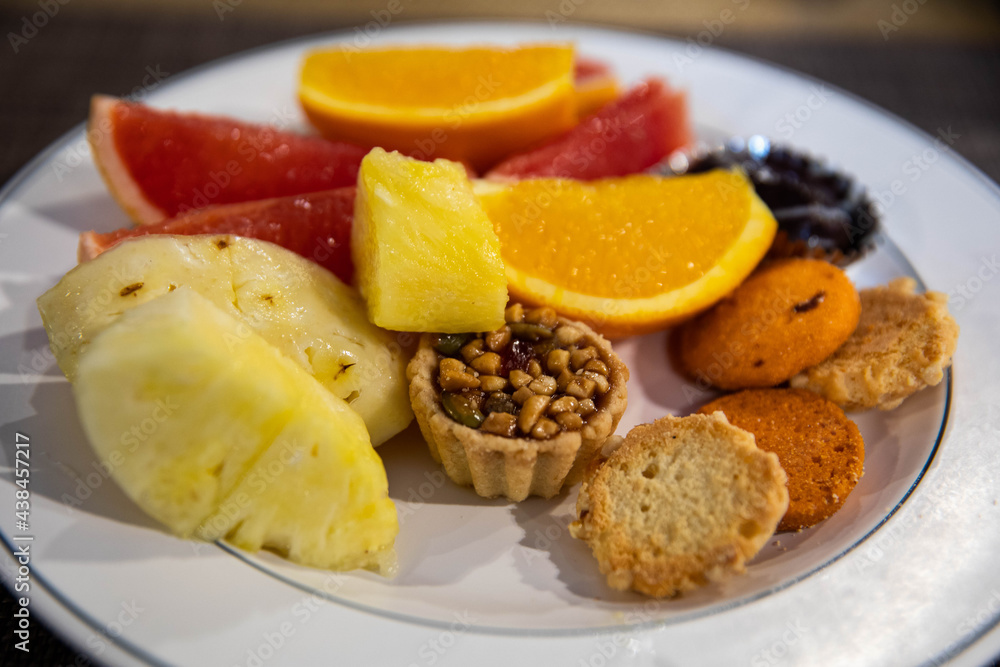 Sweet dessert with grapefruit, orange, pineapple and sweets on plate Sweet dessert with grapefruit, orange, pineapple and sweets on plate
