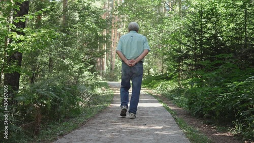 Senior active fit man walking on the forest patway, country walk photo