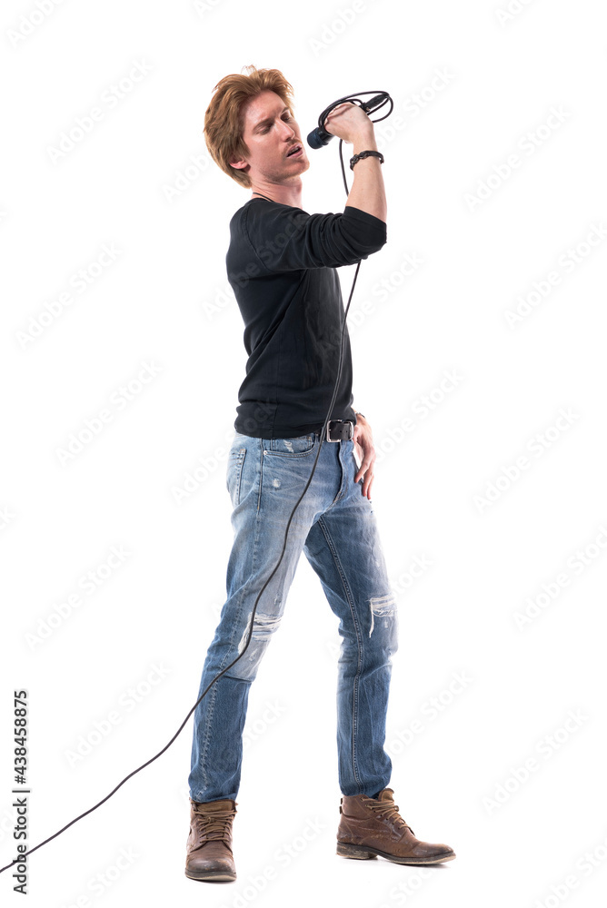 Handsome young stylish singer singing on microphone with closed eyes. Full body length isolated on white background. Handsome young stylish singer singing on microphone with closed eyes. Full body length isolated on white background.