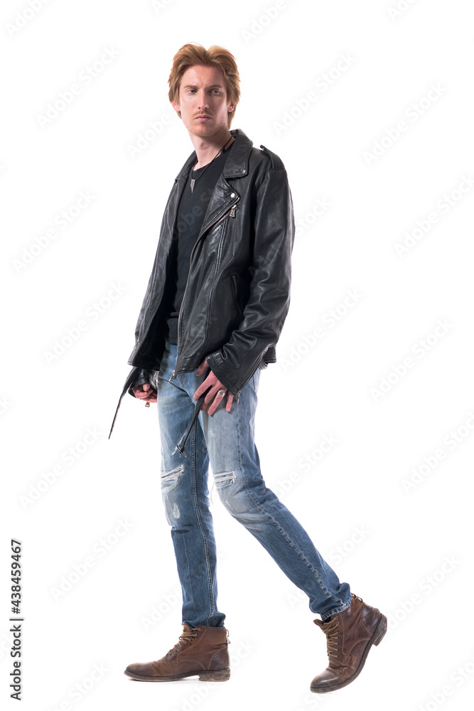 Side view of handsome biker or rocker walking and looking behind confident. Full body length isolated on white background. Side view of handsome biker or rocker walking and looking behind confident. Full body length isolated on white background.