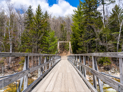 A wooden bridge on the mountain Pemigewasset river in the forest. Lincoln Woods Trail in the White Mountains