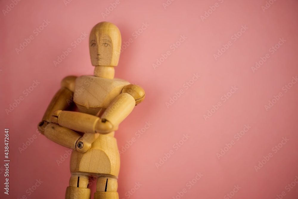 wooden dummy doll with crossed arms on pink background. wooden dummy doll with crossed arms on pink background.