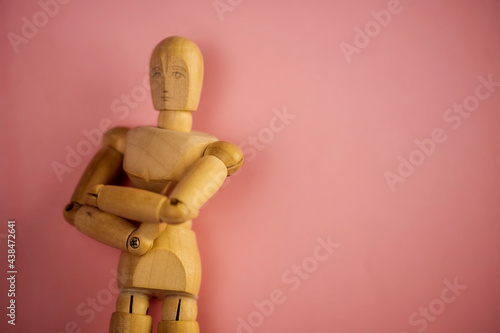 Cuadro en lienzo wooden dummy doll with crossed arms on pink background.