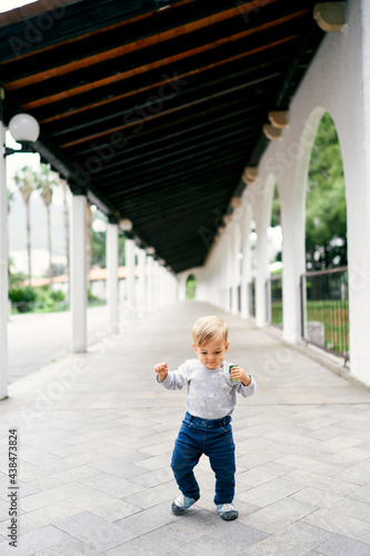 Kid walks on stone tiles in patio 