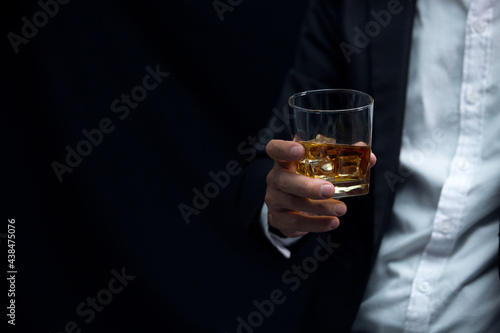 Man wearing a suit whiskey glass of liquor 