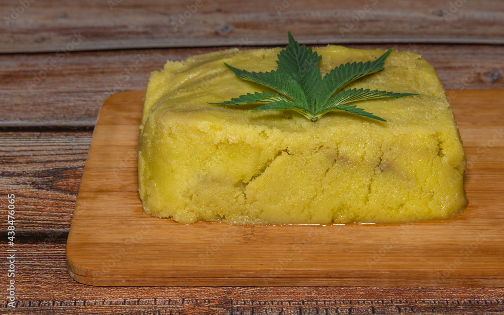 Marijuana butter on wooden table with green leafs Marijuana butter on wooden table with green leafs