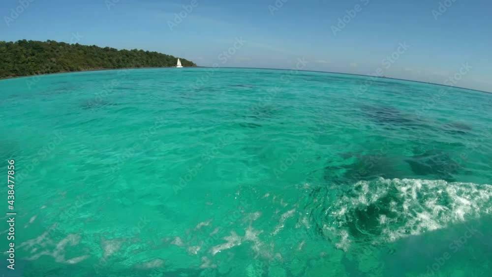 clear ocean water see-through from surface to bottom of the sea. wave ripple and reflection from day sunlight shine on blue liquid. small sailing boat sails on the sea. wide-angle view water footage clear ocean water see-through from surface to bottom of the sea. wave ripple and reflection from day sunlight shine on blue liquid. small sailing boat sails on the sea. wide-angle view water footage