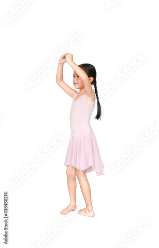 Little Asian child girl ballerina in pink tutu skirt isolated on white background. Kid practise her dance. Children ballet dancer side view.
