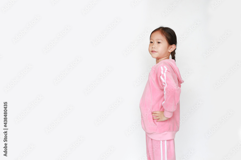 Adorable little Asian child girl in pink tracksuit or sport cloth doing exercises over white background. Adorable little Asian child girl in pink tracksuit or sport cloth doing exercises over white background.