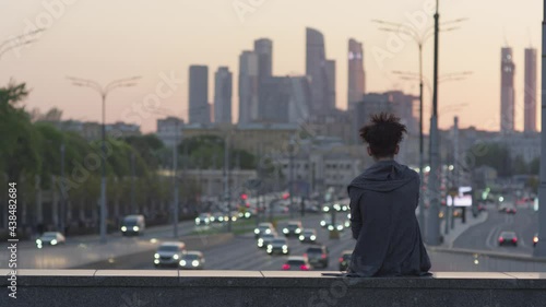Man on the bridge. Evening traffic in the city. Moscow city.