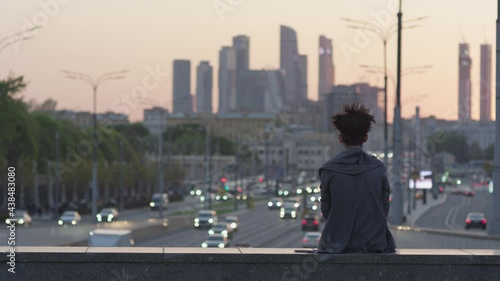 Man on the bridge. Evening traffic in the city. Moscow city.