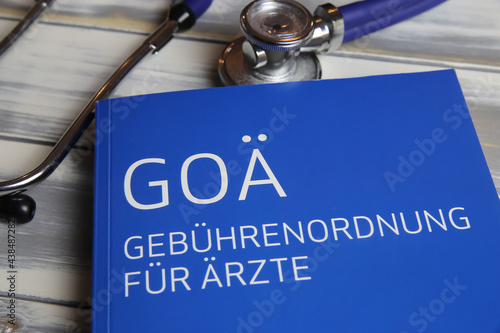 Viersen, Germany - May 9. 2021: Closeup of isolated book with stethoscope about german doctors scale of fees (Gebuhrenordnung, goa) for private insurance (focus on center of upper lettering)