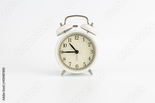 White retro clock alarm clock on white background shows 10:45 am or 10:45 pm or 22:45