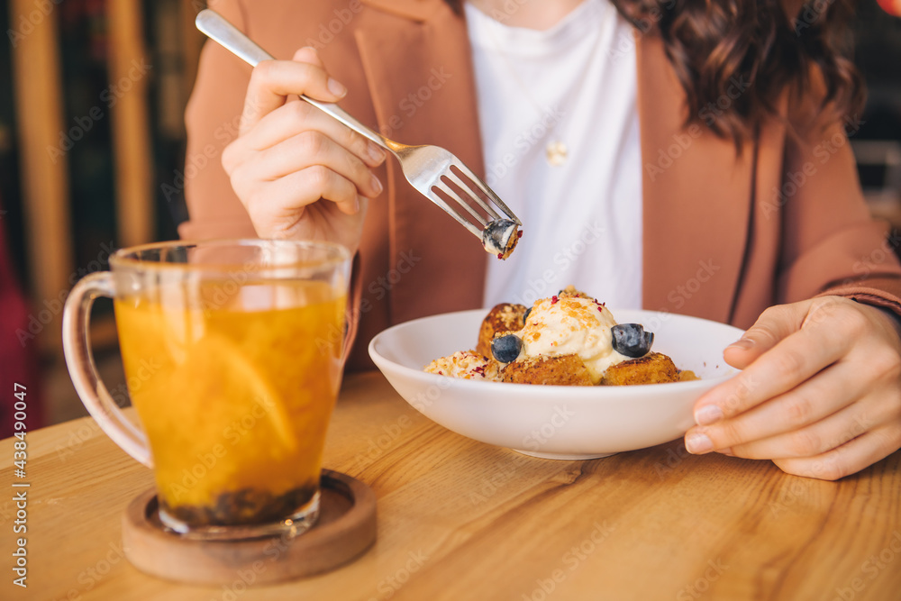 smiling beautiful woman in cafe eating cake with ice cream and blueberries smiling beautiful woman in cafe eating cake with ice cream and blueberries