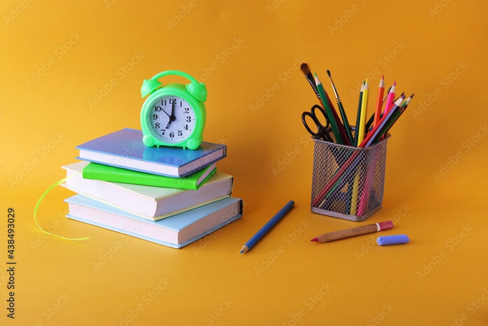 Fototapeta premium Books, alarm clock, stationery on the table, education concept, back to school