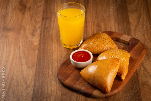 Arabic meat sfiha with juice cop on the table.