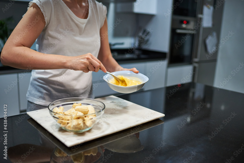 Woman whisking eggs for a banana pancake recipe Woman whisking eggs for a banana pancake recipe