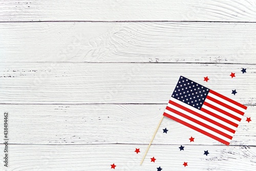 Happy 4th of July background mockup with USA flag and red and blue stars on washed wood surface.