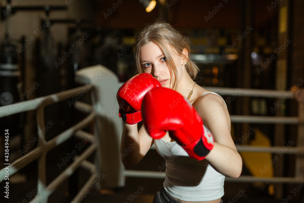 beautiful young woman in training in boxing gloves 