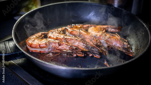 Grilled prawn in a frying pan on a dark background. Seafood appetizer.