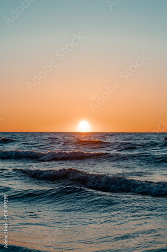 Zachodzące słońce w falach morza bałtyckiego