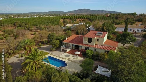 Traditional European villa with pool, solar panel and well-kept garden, aerial view from the sky. Portugal