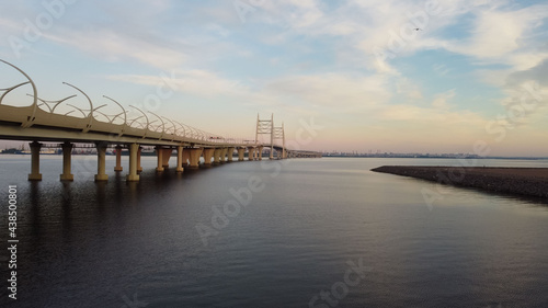 Aerial view of the cable-stayed bridge and autobahn over the bay at sunset © Elena