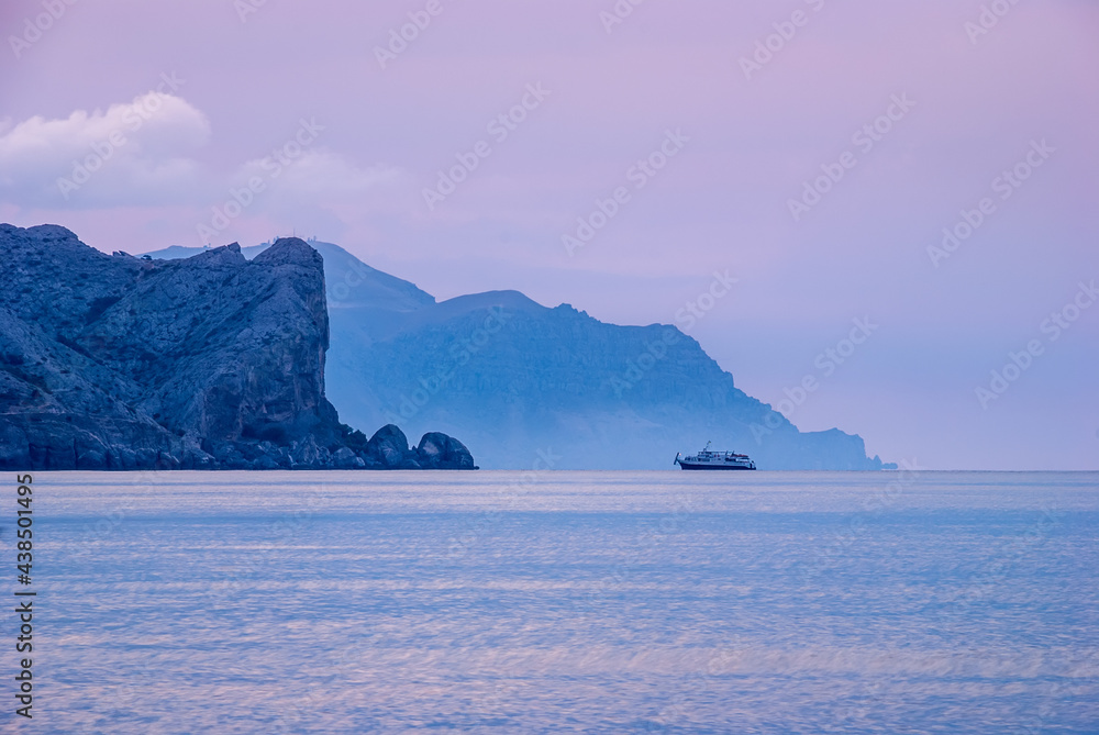 Morning seascape. Sea water at long exposure, stones and rocks. Beautiful sky with clouds.