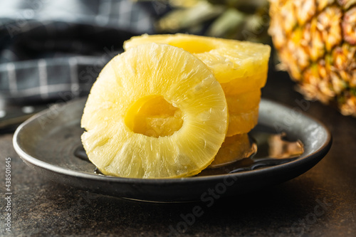 Canned sliced pineapple fruit on plate.