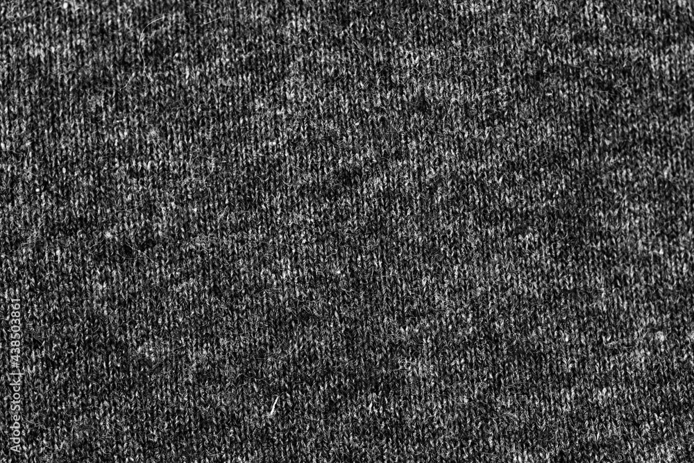 Fototapeta premium Woolen knitted black texture background, warm cloth textile material close-up photo