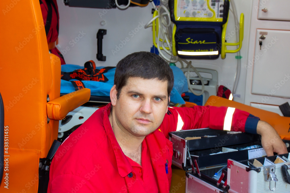 Ambulance worker in red uniform near the car. Ambulance worker in red uniform near the car.