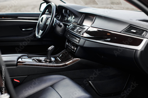 Luxury modern car Interior. Steering wheel, black leather seats, shift lever and dashboard.